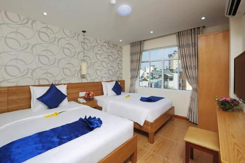 Cette chambre comprend deux lits et une télévision. dans l'établissement Ailen Hotel, à Hô-Chi-Minh-Ville