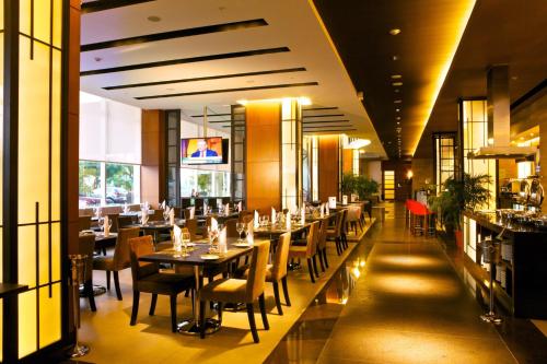 a restaurant with tables and chairs and a bar at Holiday Inn Guayaquil Airport, an IHG Hotel in Guayaquil