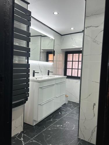 ein weißes Bad mit einem Waschbecken und einem Fenster in der Unterkunft Love room La Parenthèse Carnoules in Carnoules