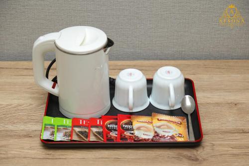 taca z dzbankiem do herbaty i kubkiem na stole w obiekcie Afsona Hotel w mieście Buchara