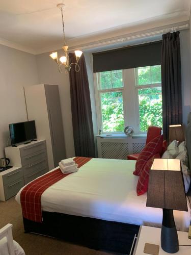 a bedroom with a large bed and a window at Chandlers Country House in Rothesay