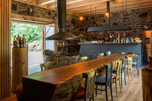 eine große Holzbar in einem Restaurant mit Stühlen in der Unterkunft Stodola Ve Žlebě 