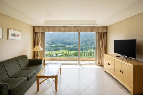 a living room with a couch and a large window at Oak Valley Resort Valley Village in Wonju