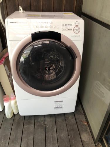 a washer and dryer sitting on a wooden floor at GUEST HOUSE NAGORIYA in Hikone