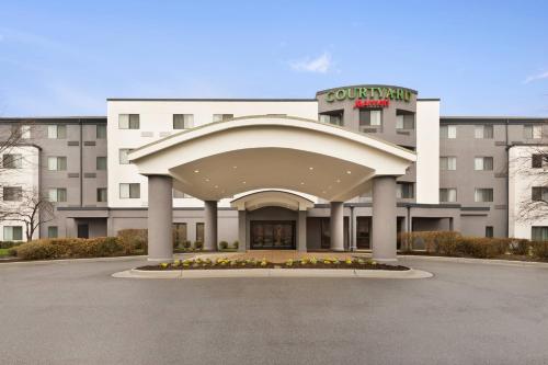 un hotel con un gran edificio con una gran entrada en Courtyard by Marriott Potomac Mills Woodbridge, en Woodbridge