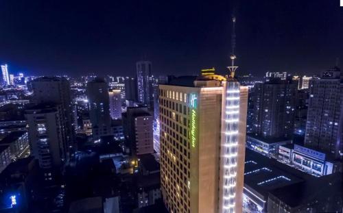 oświetlony budynek w mieście w nocy w obiekcie Holiday Inn Taiyuan City Center w mieście Taiyuan