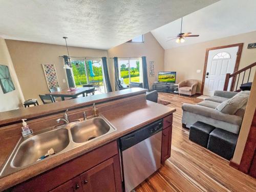 a kitchen with a sink and a living room at Bridges Bay Vacation Cabin 33 in Arnolds Park