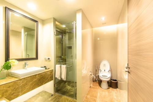 a bathroom with a toilet and a sink and a shower at Qiss Residence by Bliston in Bangkok