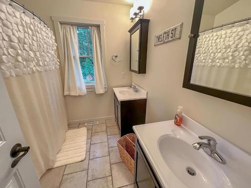 La salle de bains est pourvue d'une baignoire, d'un lavabo et d'un miroir. dans l'établissement Monarch Cove Home off West Lake, à Spirit Lake