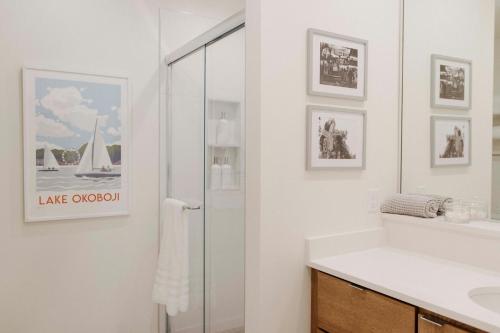 La salle de bains blanche est pourvue d'un lavabo et d'un miroir. dans l'établissement Okoboji Flats 1 - East Okoboji Views, à Okoboji