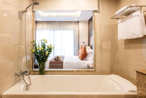 曼谷的住宿－Qiss Residence by Bliston - SHA Plus，一间带浴缸和大镜子的浴室