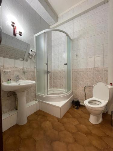 a bathroom with a toilet and a shower and a sink at Belon Land in Astana