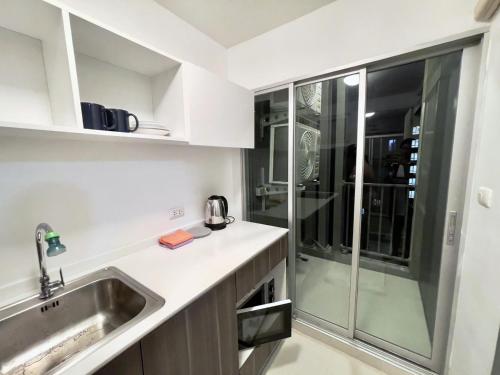 uma cozinha com um lavatório e uma cabina de duche em vidro em Condo in Town in Chiangmai em Chiang Mai