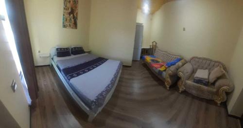 een slaapkamer met een bed en een bank bij Fraish air boutige in Qusar
