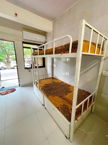 a bedroom with two bunk beds in a room at Frostybeds Hostel Kharghar Navi Mumbai in Navi Mumbai