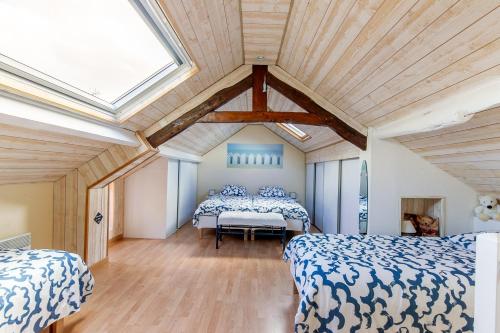 deux lits dans une chambre avec plafonds en bois dans l'établissement La Rochambelle - Charmante maison de pêcheurs, à Bernières-sur-Mer