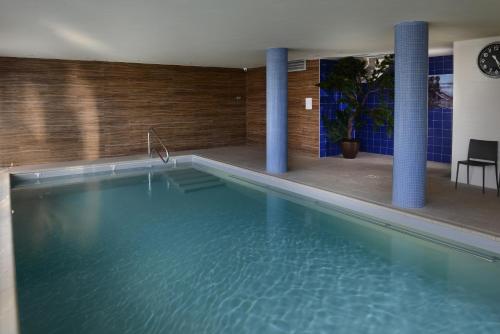 - une grande piscine avec colonnes bleues dans un bâtiment dans l'établissement Domitys Les Côteaux de l'Esterel, à Fréjus
