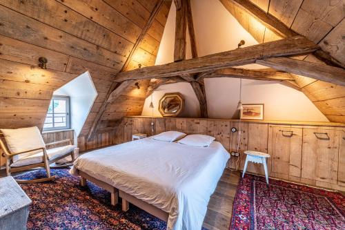 een slaapkamer met een bed in een kamer met houten wanden bij Colombier - Charmante maison avec jardin 