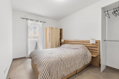 une chambre blanche avec un lit et une fenêtre dans l'établissement Le Corinthe - Appt classé 3 étoiles et climatisé, à Marseillan