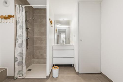une salle de bain avec douche et lavabo dans l'établissement Le Corinthe - Appt classé 3 étoiles et climatisé, à Marseillan