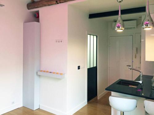 a kitchen with a counter and a pink wall at Maisons-Alfort superbe appartement de standing in Maisons-Alfort