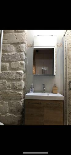 a bathroom with a sink and a stone wall at Maisons-Alfort superbe appartement de standing in Maisons-Alfort