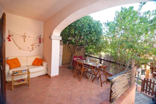 a patio with a couch and a table and chairs at CASA PAU in Porto Ottiolu