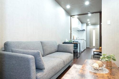 una sala de estar con un sofá y una mesa en Kyobashi house Entire house for rentー 京橋一軒家完全貸切, en Osaka