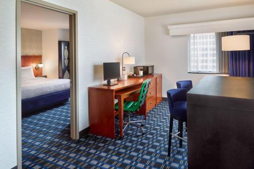 アーリントンにあるコートヤード アーリントン クリスタル シティ/レーガン ナショナル エアポートのデスクとベッドが備わるホテルルームです。