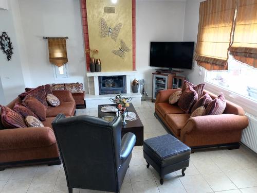 uma sala de estar com sofás e uma televisão em Village Villa 