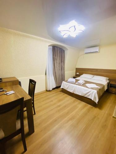 a bedroom with a bed and a table and a light at HOTEL SUNRISE in Kutaisi