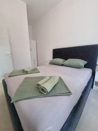 een slaapkamer met 2 bedden en handdoeken bij Bass Apartment in Pula