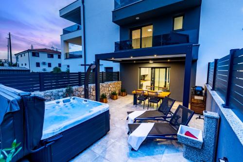 a hot tub on the balcony of a house at Superior Apartments in Malinska