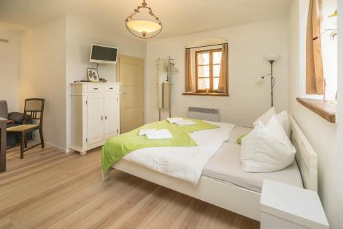 a bedroom with a large bed with a green blanket at Jägerhaus auf Schloss Neuenburg in Freyburg