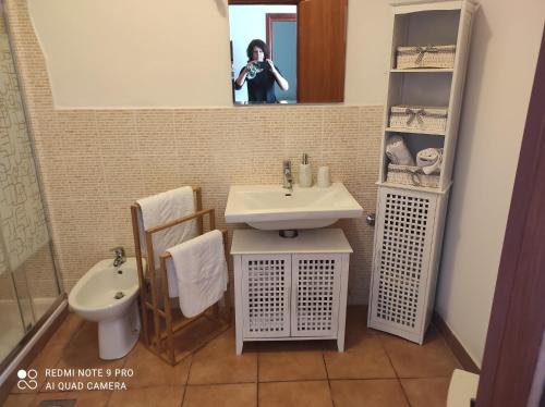 une femme prenant une photo d'une salle de bains avec lavabo dans l'établissement Casa Deborah, à Ripenda Kras