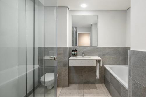 a bathroom with a toilet and a sink and a tub at Crowne Plaza - Dar Es Salaam by IHG in Dar es Salaam