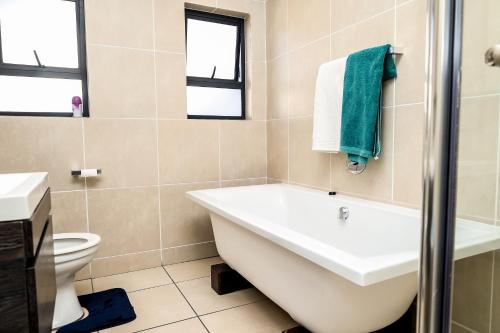 uma casa de banho com uma banheira, um lavatório e um WC. em Fullmoon Two Bed Apartment em Antwerp