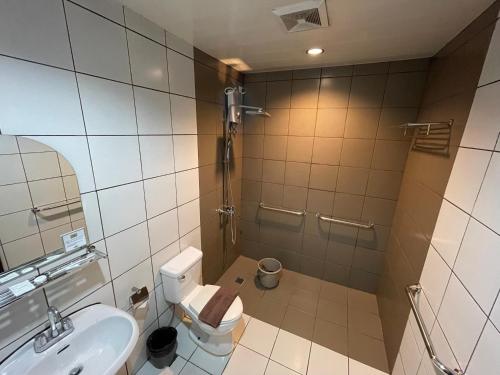 a bathroom with a toilet and a sink and a shower at Inn De Avenida, Makati in Manila