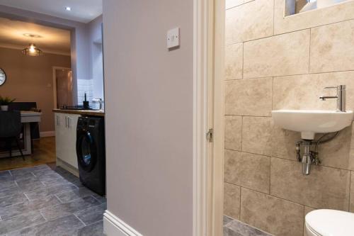 uma casa de banho com um lavatório e uma máquina de lavar roupa em Rosa: Seaside home recently renovated em Portsmouth