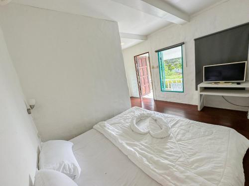 een slaapkamer met een wit bed en een televisie bij Capital O 75411 Navagio​ boutique​ Koh​ Chang​ in Trat