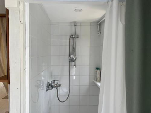 een douche met een douchekop in de badkamer bij Huisje op de dijk in Kortenhoef