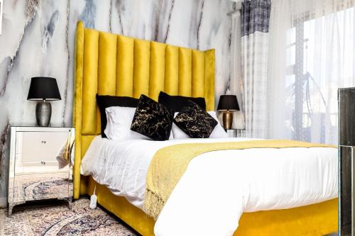 a bedroom with a large bed with a yellow headboard at Fullmoon Two Bed Apartment in Antwerp