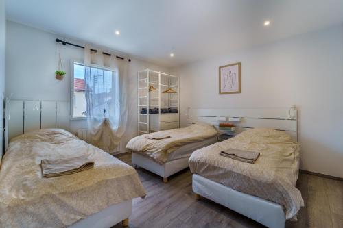 um quarto com 2 camas e uma janela em Maison calme avec terrasse garage centre-ville B em Dijon