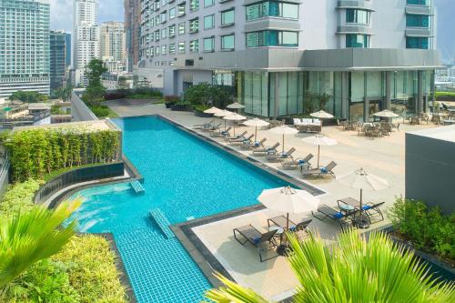 an overhead view of a swimming pool with chairs and umbrellas at Hotel JAL City Bangkok in Bangkok