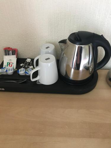 - une bouilloire et des tasses sur un plateau noir dans l'établissement Foyers Roost, à Foyers