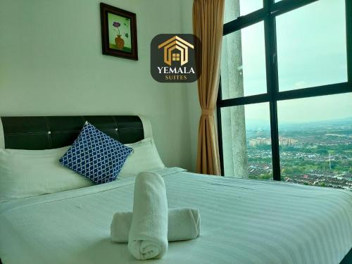 een bed met een handdoek en een raam bij Yemala Suites at Skyloft - Johor in Johor Bahru