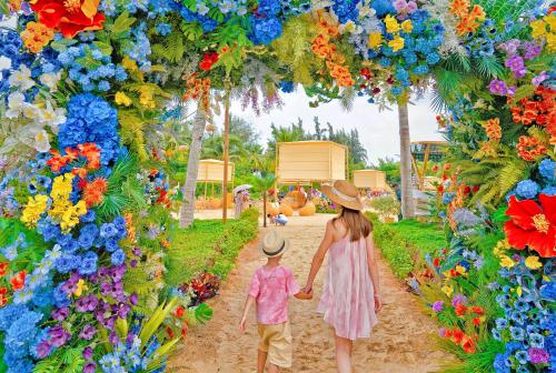 una mujer y un niño caminando por un jardín de flores en Shangri-La Sanya, en Sanya