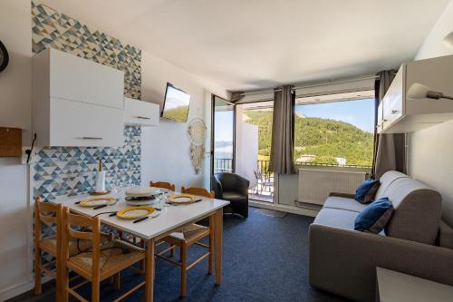 un salon avec une table et un canapé dans l'établissement L'Esperta - Studio proche station de ski et ESF, à Eaux-Bonnes