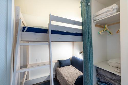 a room with two bunk beds and a couch at L'Esperta - Studio proche station de ski et ESF in Eaux-Bonnes