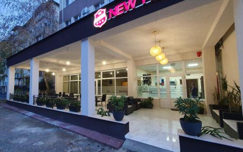 a store front of a restaurant with potted plants at Hotel New in Baia Mare